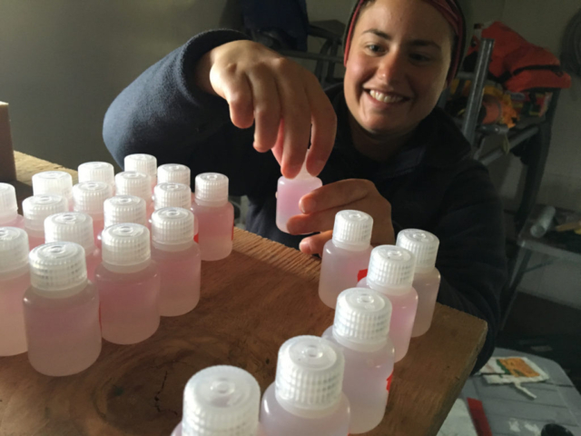 Stephanie Arcusa filters water samples from Lake Peters